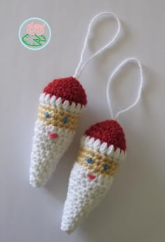 two crocheted christmas ornaments hanging from strings