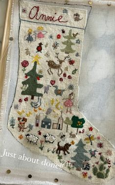 an embroidered christmas stocking hanging on a wall