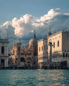 the buildings are all along the water with clouds in the background