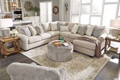 a living room filled with furniture and a large rug on top of a hard wood floor