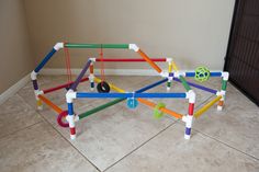 a colorful structure made out of plastic pipes on the floor