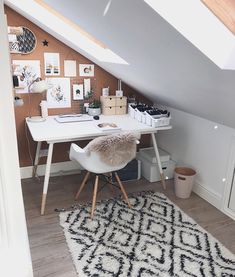 an attic bedroom with a desk and chair in front of the window, along with pictures on the wall