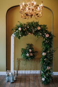 a room with a chandelier and some flowers on the wall next to it