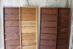 three wooden shelves sitting on top of a white sheeted floor next to each other