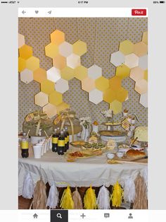 a table topped with lots of food and desserts next to honeycomb wallpaper