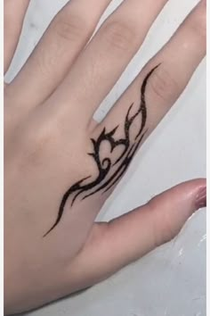 a woman's hand with a tattoo on it and a ring in the middle