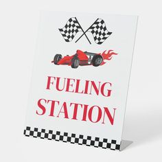 a sign that says fueling station with a racing car on it