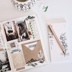 an open notebook with pictures and stickers on it next to a cup of coffee