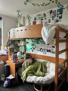 a bunk bed in a dorm room with pictures on the wall and hanging plants above it