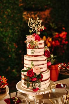 a wedding cake with red flowers on top