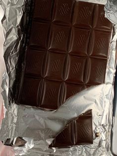 a piece of chocolate sitting on top of aluminum foil