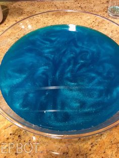 a bowl with blue liquid in it sitting on a counter