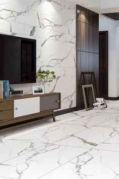 a living room with marble walls and flooring in the center, television on top of a cabinet