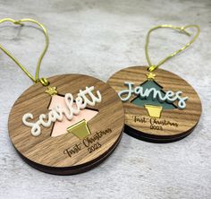 two wooden christmas ornaments with names on them