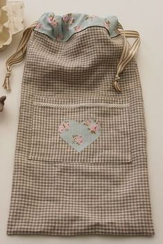 a small bag with a heart patch on the front and two flowers in the back