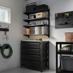 a workbench with tools hanging on the wall and other items in bins