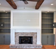 an empty living room with built in bookcases and a fireplace