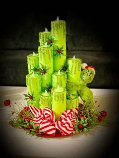 a christmas tree made out of green candles and candy canes with a teddy bear on top