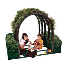 two children are sitting on a bench in front of a garden arch with plants growing out of it