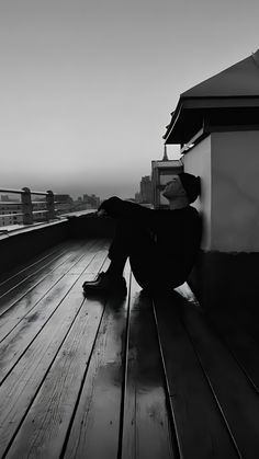 a person sitting on top of a wooden deck