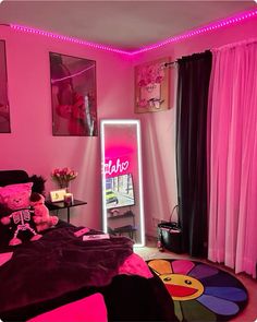 a bedroom with pink walls, black curtains and a large mirror in the corner that is lit up