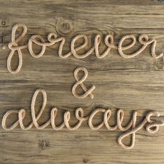 the word forever and always written in rope on a wooden surface with other words around it