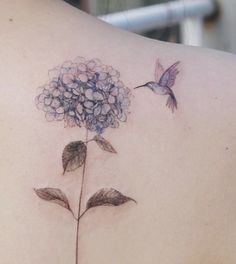 a woman's back with a flower tattoo on it