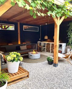 an outdoor living area with potted plants on the ground and fire pit in the middle