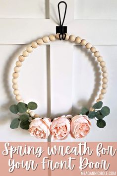 a wreath made out of wood beads with pink roses hanging from it and text saying spring wreath for your front door