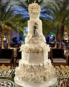 a large white wedding cake sitting on top of a table next to other desserts