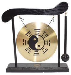 a gong that is sitting on top of a stand with a black and gold design