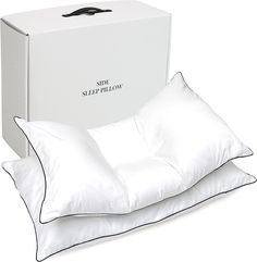 two pillows and a pillow case sitting next to each other in front of a white box