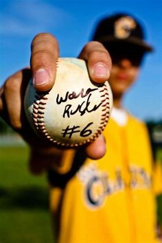 a person holding a baseball in their hand