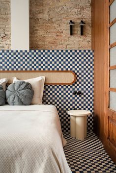 a bed sitting in a bedroom next to a brick wall