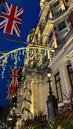 the british flag is hanging on a building with christmas lights and garlands around it