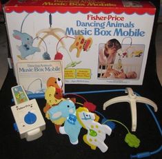 the fisher price dancing animals music box mobile is in front of its box and it's contents