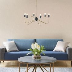 a living room with a blue couch, coffee table and chandelier