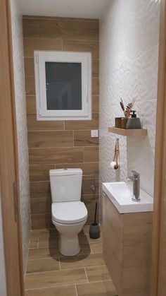 a white toilet sitting in a bathroom next to a sink