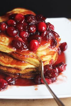 cranberry pancakes with syrup on a white plate