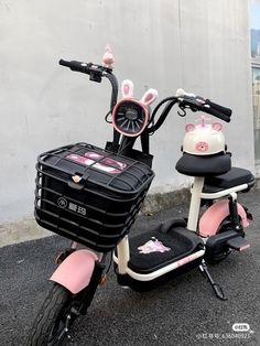 a pink and white scooter with bunny ears on it