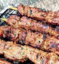 several skewers of meat sitting on top of a grill