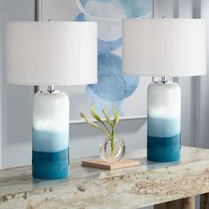 two blue and white vases sitting on top of a table