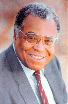 an older man in a suit and tie smiling at the camera with glasses on his face