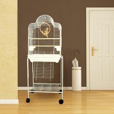 a white bird cage sitting on top of a wooden floor