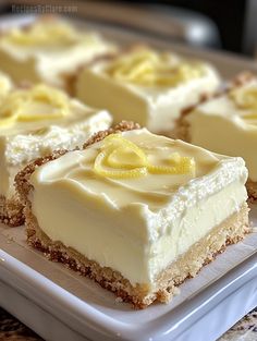 several squares of cake with lemons on top sitting on a white platter, ready to be eaten