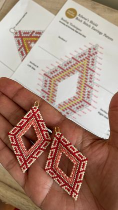 small red and yellow beaded square earrings in the palm of someone's hand