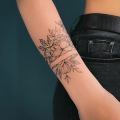 a woman's arm with a flower tattoo on the left side of her arm