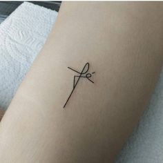 a small tattoo on the leg of a person with scissors in their hands and an arrow