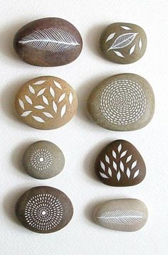 several rocks with different designs on them are arranged in the shape of leaves and circles