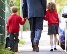 a man and two children walking down a sidewalk